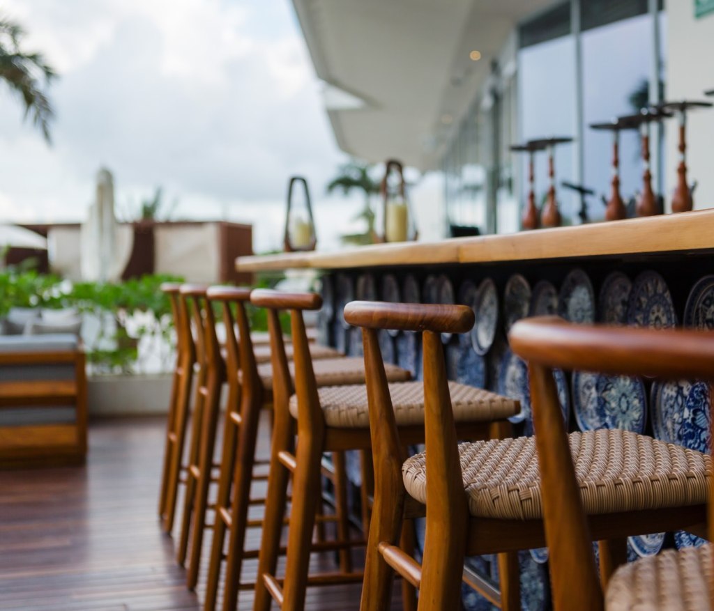 an outdoor bar at Cleo with wooden bar chairs