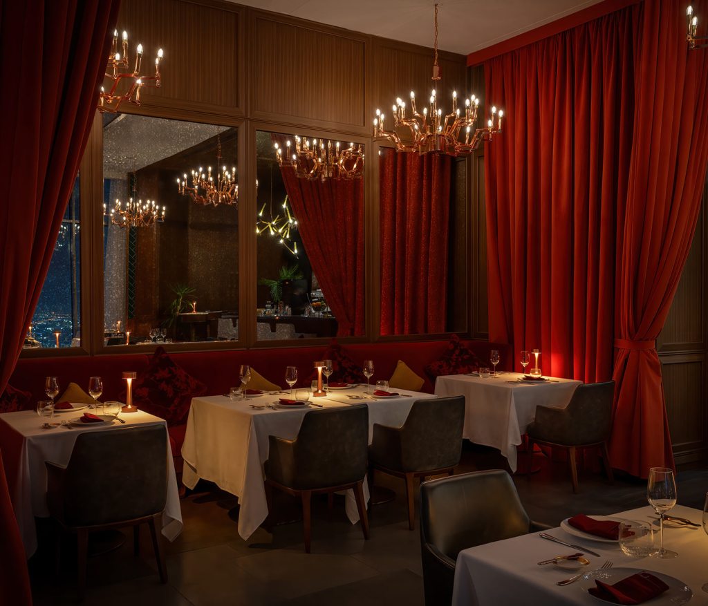 Salle à manger du Carna Dubai avec rideaux rouges