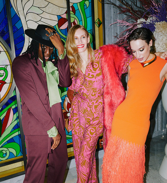 Three stylish individuals in vibrant attire striking a pose for a picture.