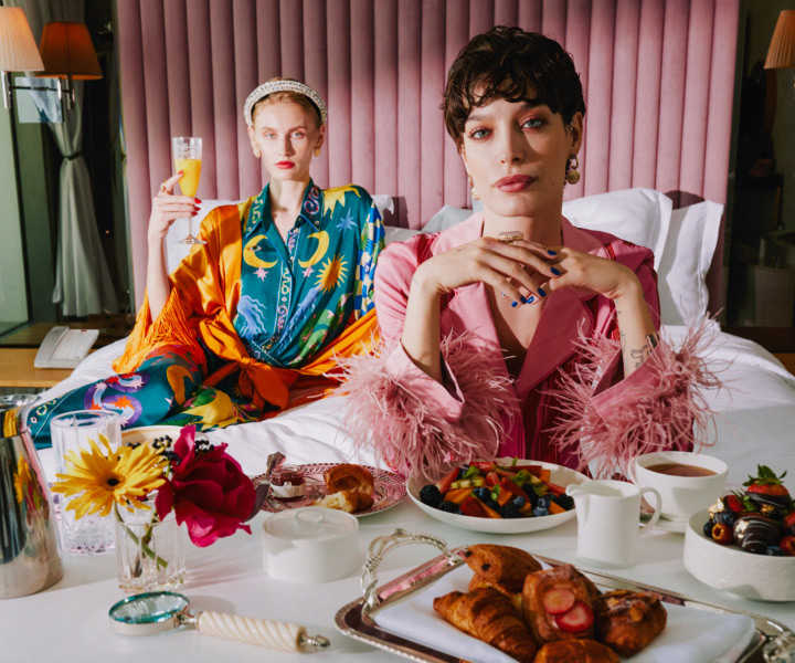 Deux femmes élégantes profitant d'une agréable matinée sur un lit luxueux, en dégustant un savoureux petit déjeuner.