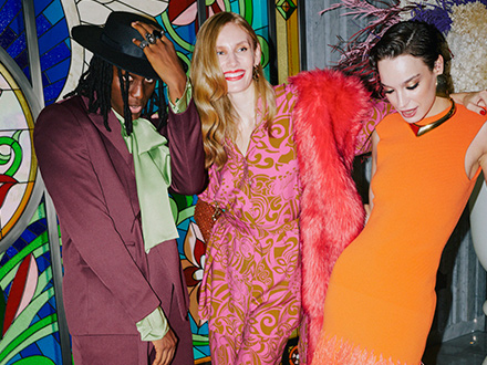 Three stylish individuals in vibrant attire striking a pose for a picture.