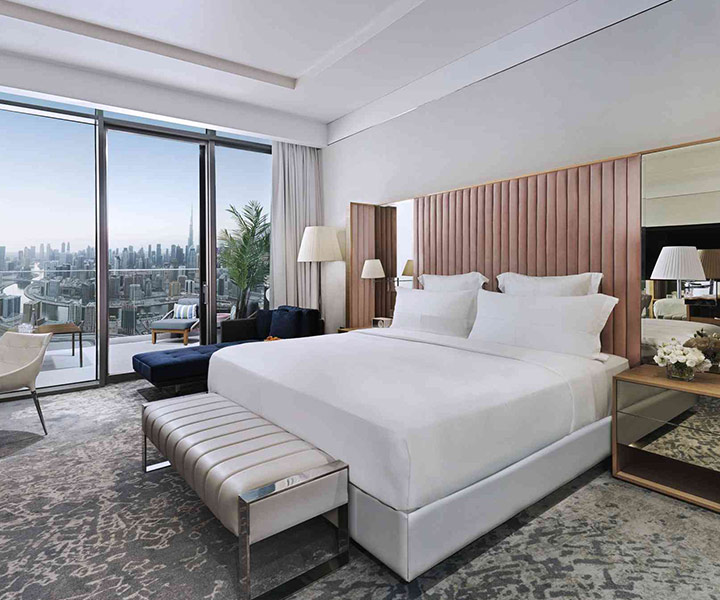 A lavish hotel room with a king-sized bed and a breathtaking cityscape view from the window.