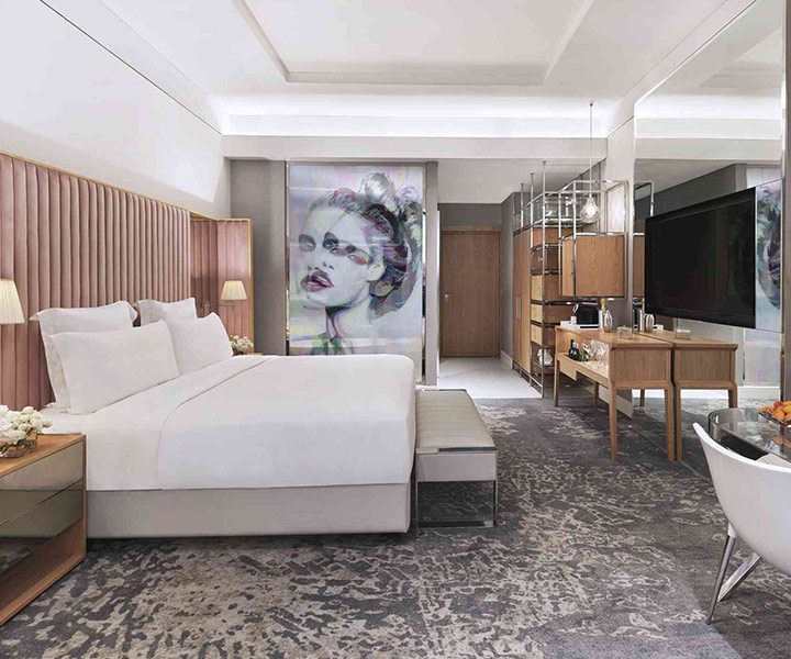 Luxurious hotel room with king-sized bed and elegant painting on wall