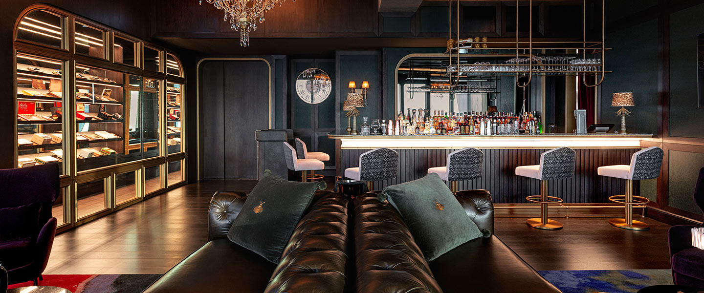 Smoke & Mirrors at SLS Dubai, a bar with elegant black leather furniture, a striking chandelier and a cigar humidor.
