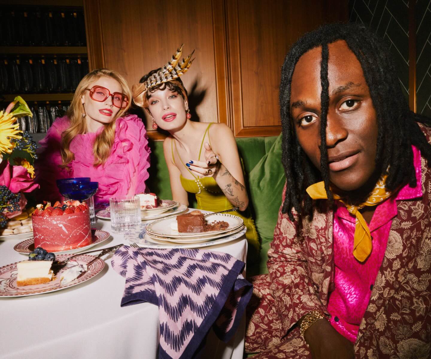 A group of friends enjoying a table full of delectable desserts in a stylish restaurant.