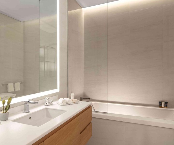A modern bathroom featuring a large mirror and sink.