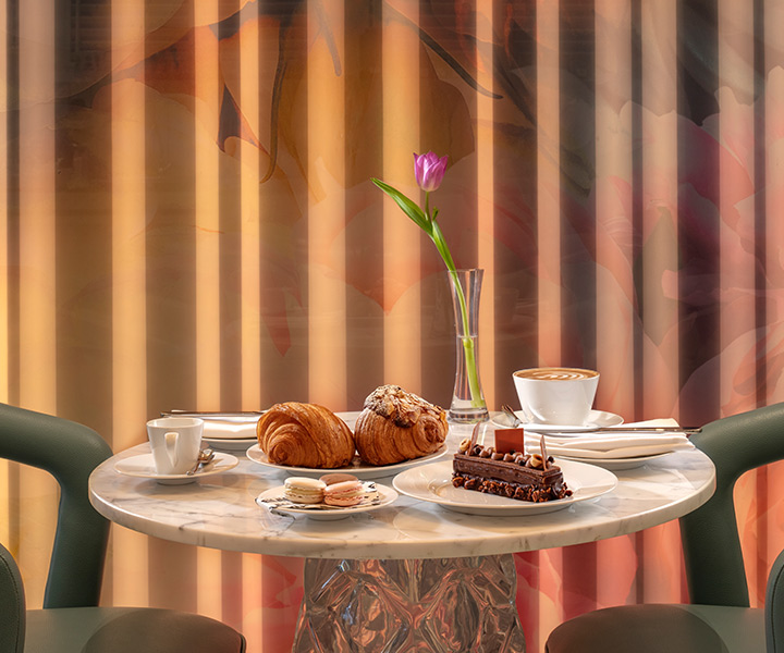 Mármol con grandes croissants, macarons, un postre de chocolate y cafés en Ellamia Dubai.