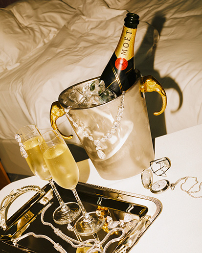 Champagne chilling in ice bucket with two champagne glasses.