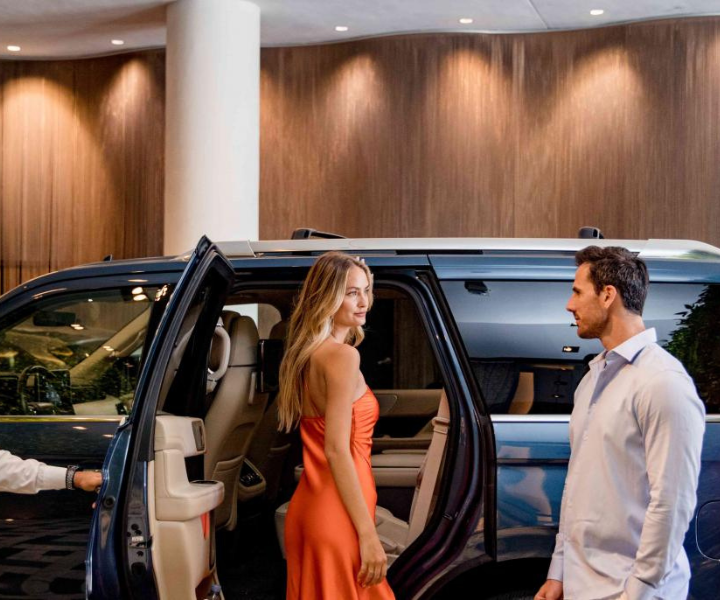 an elegantly dressed couple stepping into a lincoln car