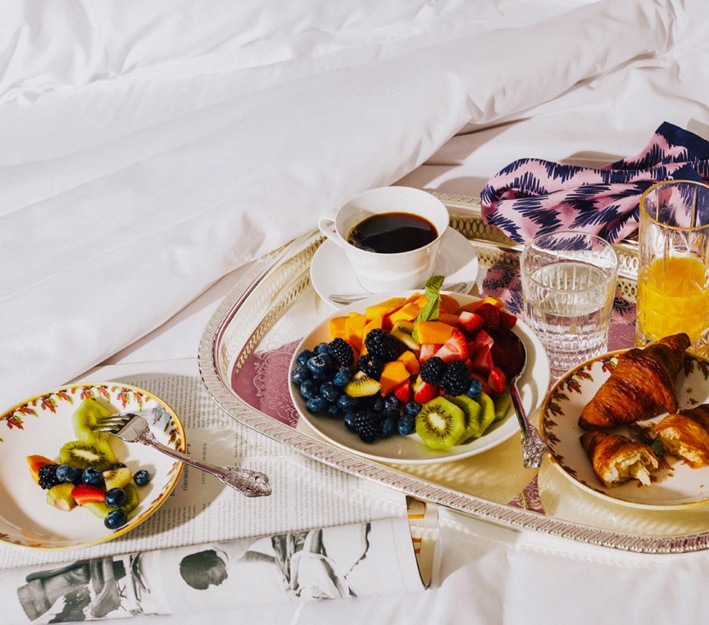 breakfast in bed with delicious spread of food and beverages