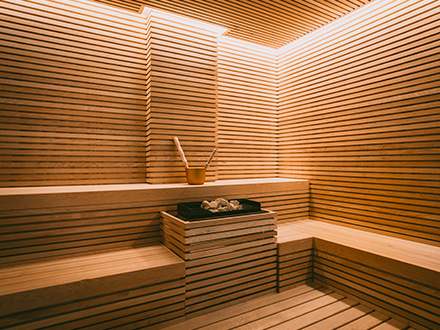 Uma sauna de madeira com um banco de madeira.