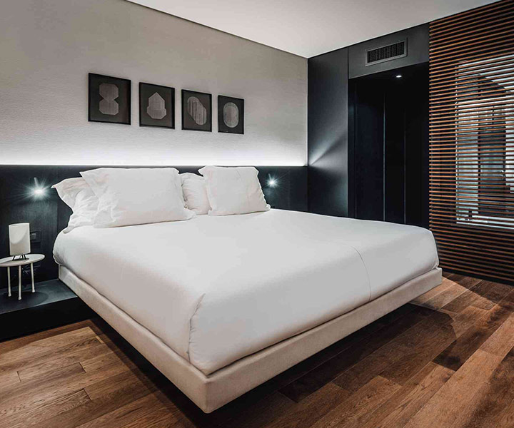 Belle chambre moderne équipée d'un lit moelleux, d'une table de nuit élégante et d'une étonnante paroi vitrée.