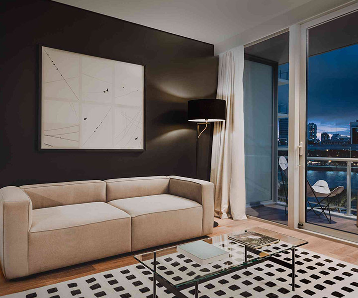 Salon luxueux avec un canapé élégant, une superbe table basse et une grande fenêtre offrant une vue imprenable.