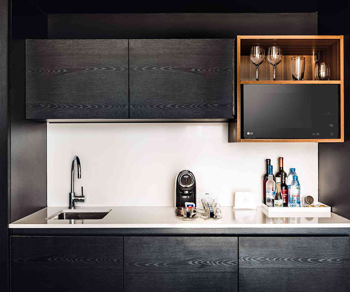 Luxurious kitchen with sleek sink, modern microwave, and elegant wine rack.
