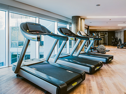 Two treadmills in a gym facing a large window. 