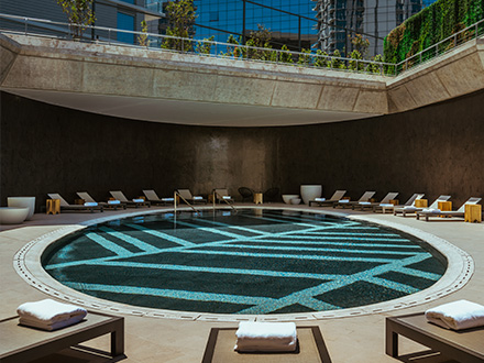 A large round pool with daybeds surrounding it.
