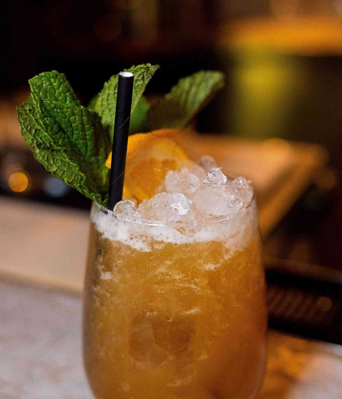 A refreshing icy cocktail made with crushed ice and garnished with mint and orange