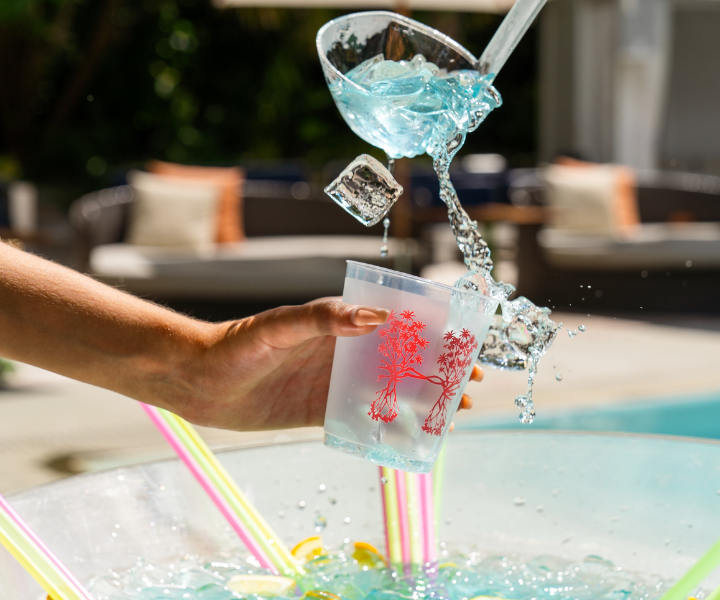 a spectacular blue drink being poured into a hyde beach cup