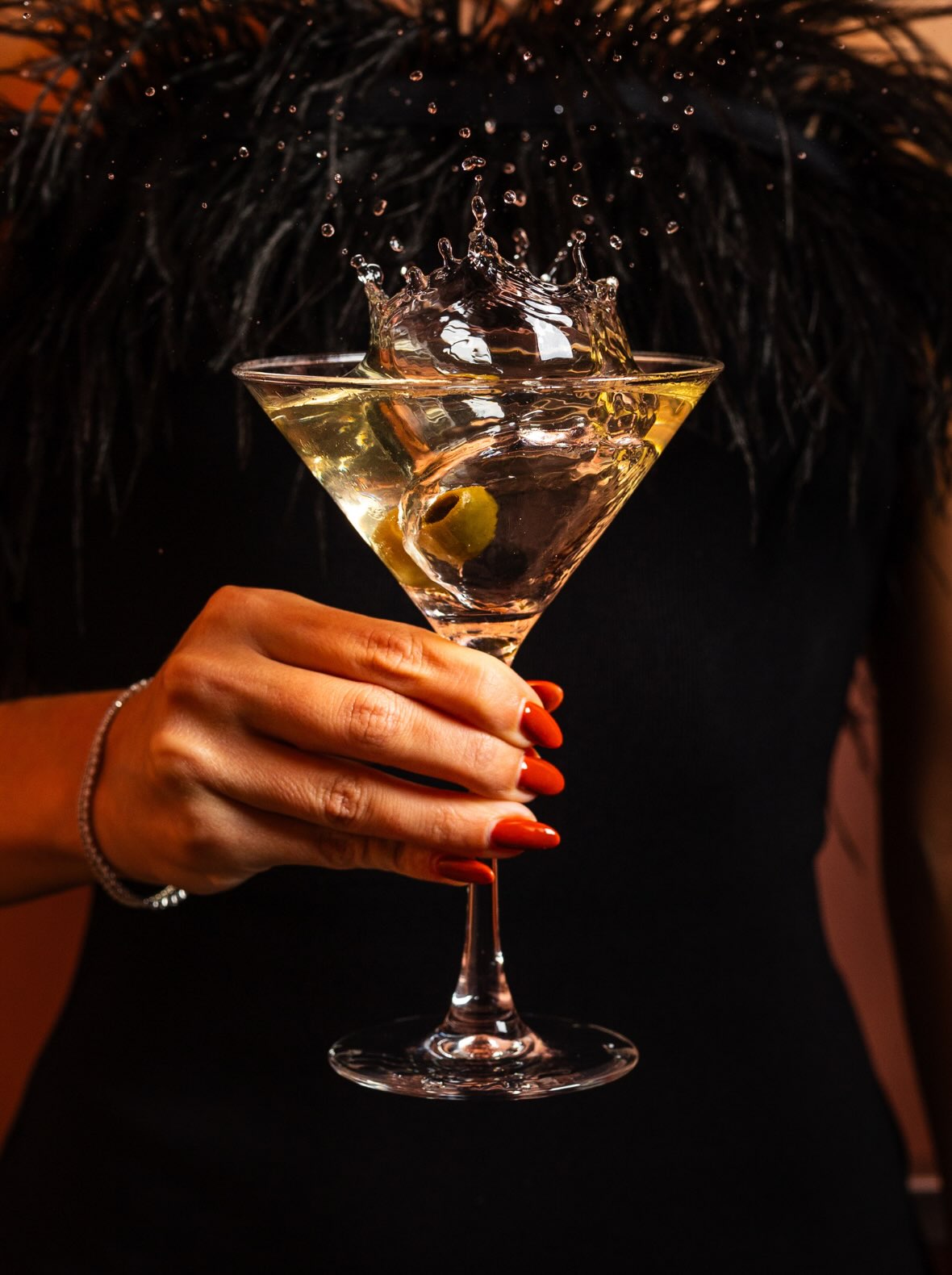 a woman with red nails holding a martini 