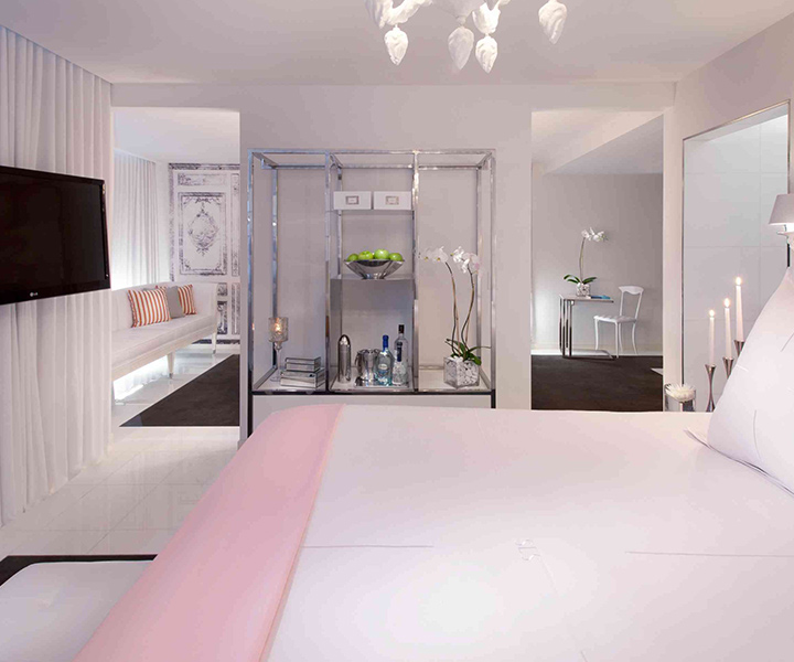 Luxurious bedroom with a plush bed, sleek television, and elegant mirror.