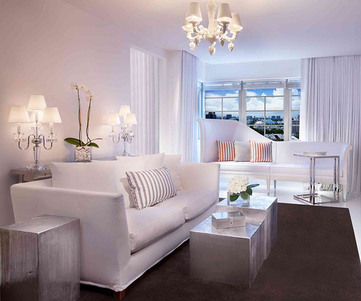 Luxurious living room featuring a pristine white couch and elegant white table.