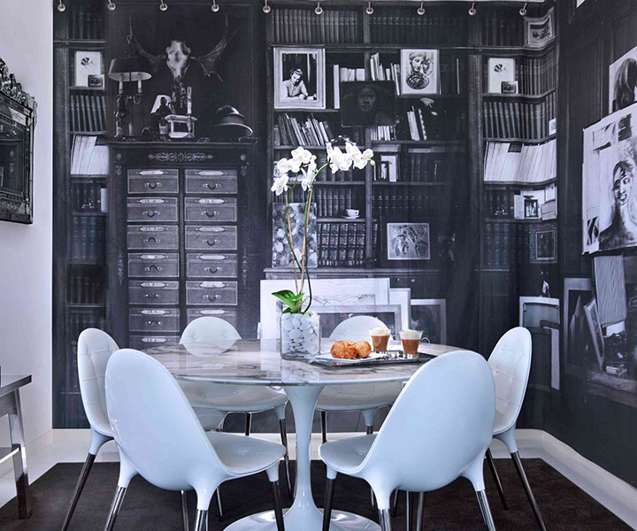A lavish dining room adorned with a grand black and white mural.