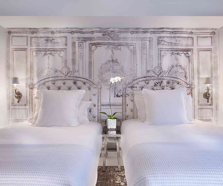 Exquisite room adorned with a captivating wall mural, showcasing two elegant beds.