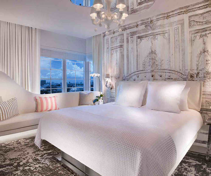 Quarto opulento adornado com uma cama luxuosa e um lustre requintado.