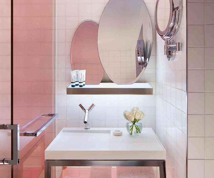 Lujoso cuarto de baño con elegante lavabo, estilizado espejo y moderna ducha.