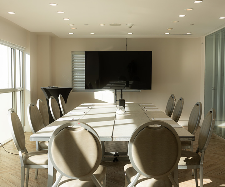 Une salle de conférence avec une grande table entourée de chaises.