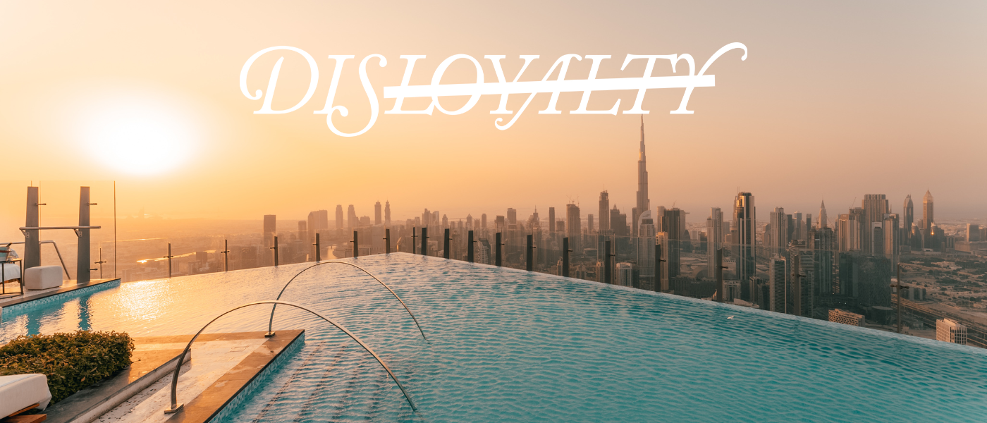 a beautiful infinity pool at golden hour with the disloyalty logo