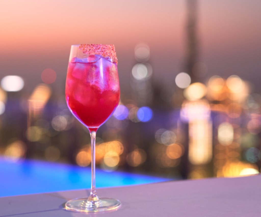 Cocktail with a pool and the city of Dubai in the background