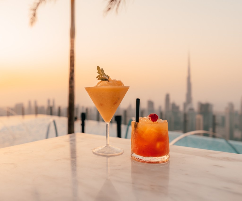 Two cocktails at sunset with Dubai in the background at Privilege Dubai