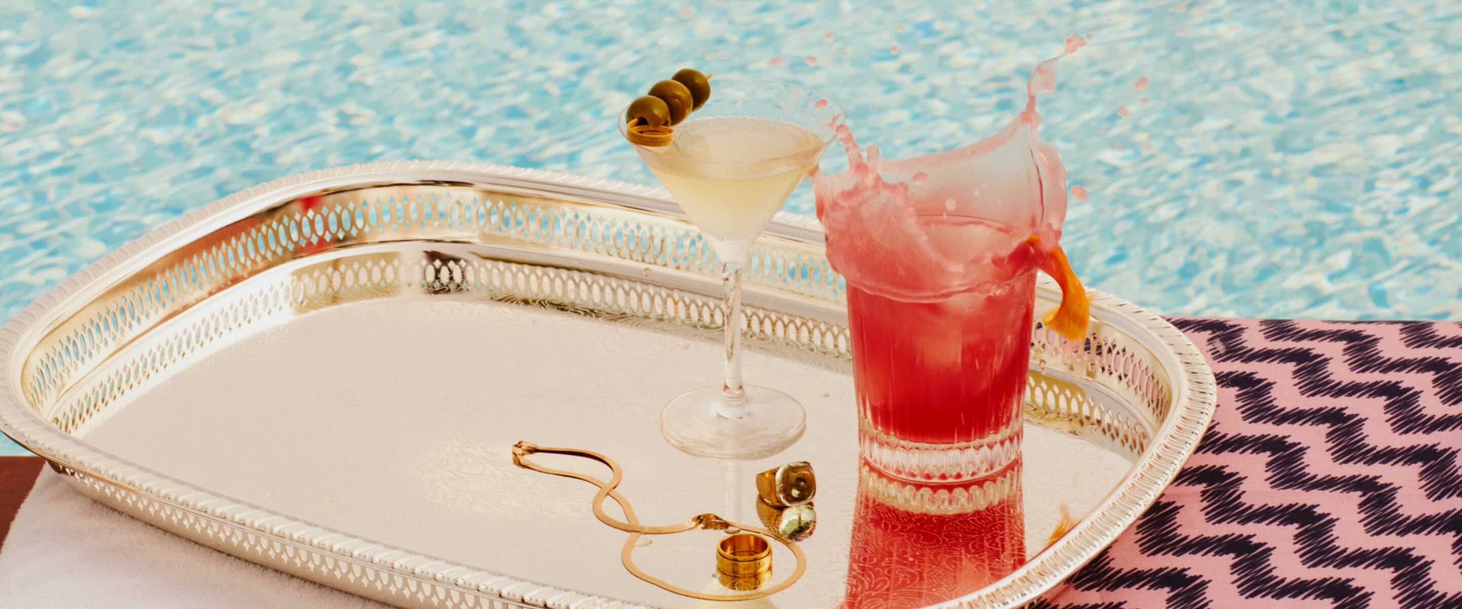 image of two cocktails on a silver tray by the pool