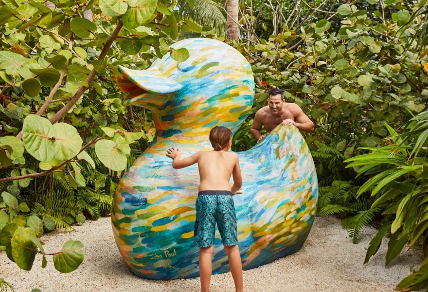 a father and son at the beach next to the iconic sls duck