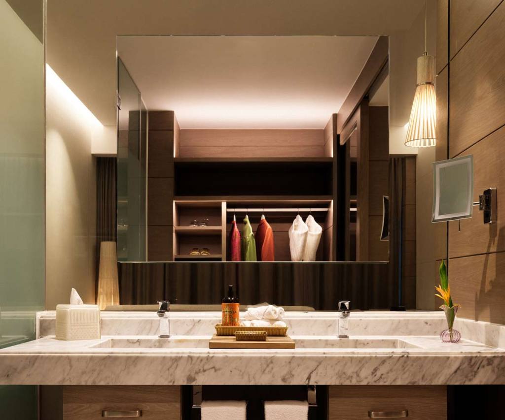the double vanity with a large mirror reflecting the closet