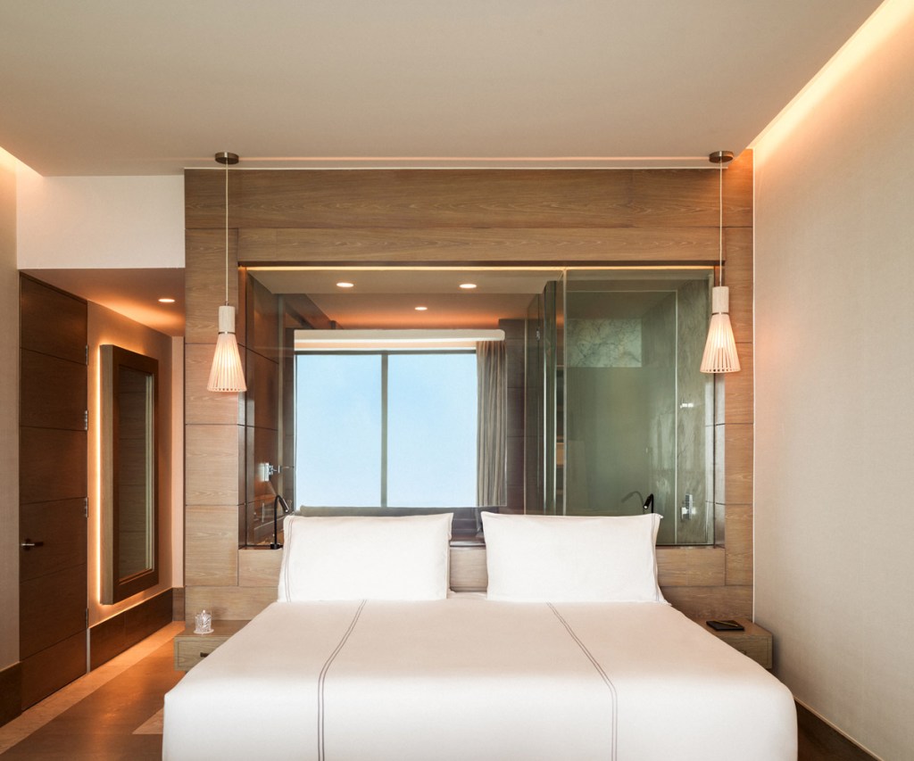 the front view of a king bed in a room at sls playa mujeres
