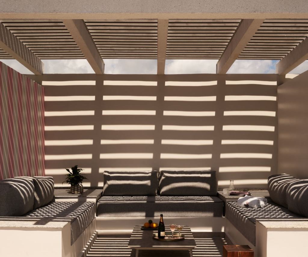 an outdoor terrace with a pergola over it causing shade.