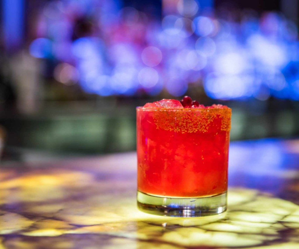 A red pomegranate cocktail sits on the bar at Bar Central