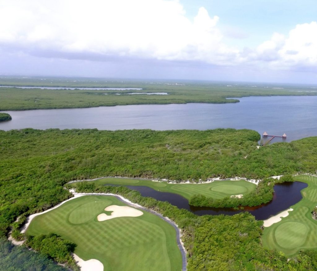 a beautiful lush golf course on a lagoon at sls playa mujeres