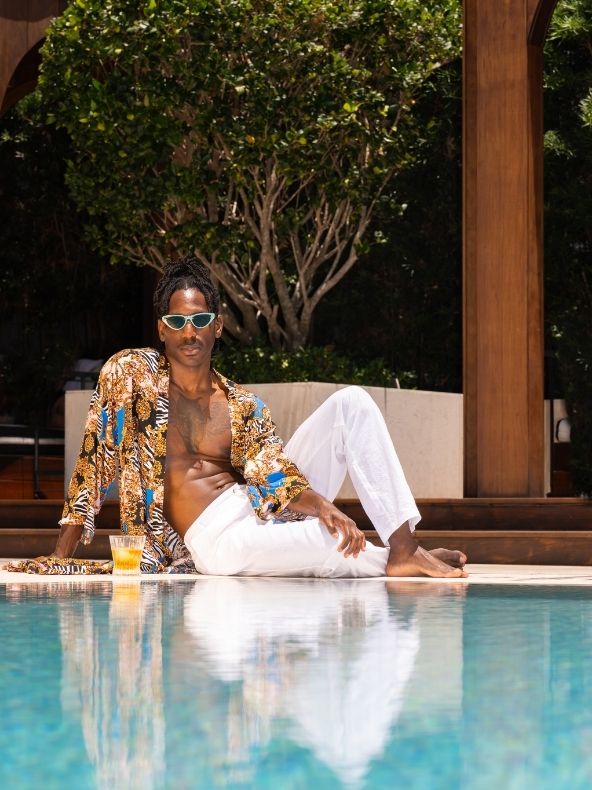 Model sits by pool with cocktail at SLS LUX Brickell