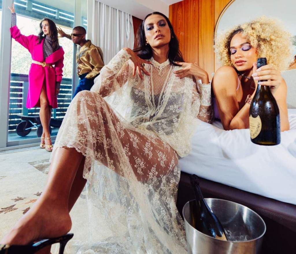 Models sit around the SLS South Beach Villa Penthouse celebrating together with champagne