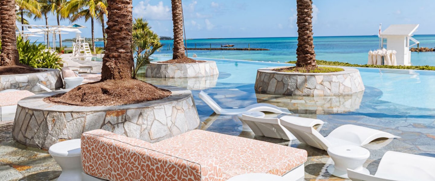 lounge chairs by the pool at sls baha mar with palm trees