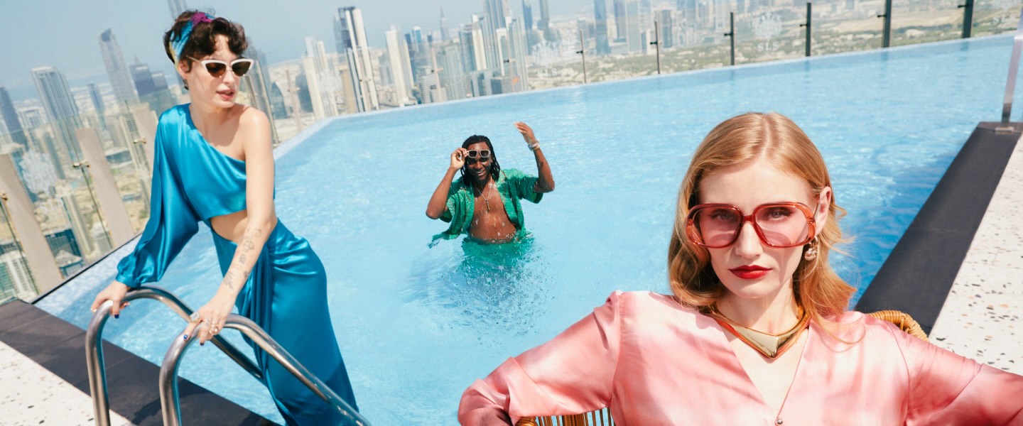 three people in the sky high pool at sls dubai in elevated clothing
