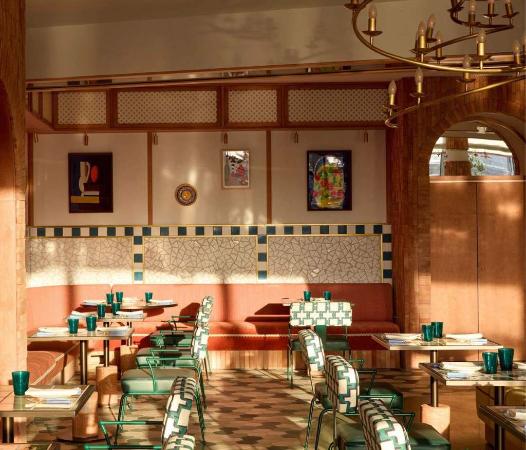 Retro-themed Anxova restaurant at SLS Barcelona with checkered tables, brick walls, and decorative arches.
