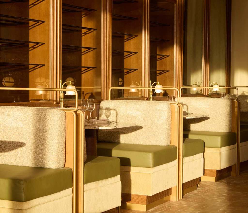 Green and beige seating with dramatic lighting at Lora restaurant at SLS Barcelona