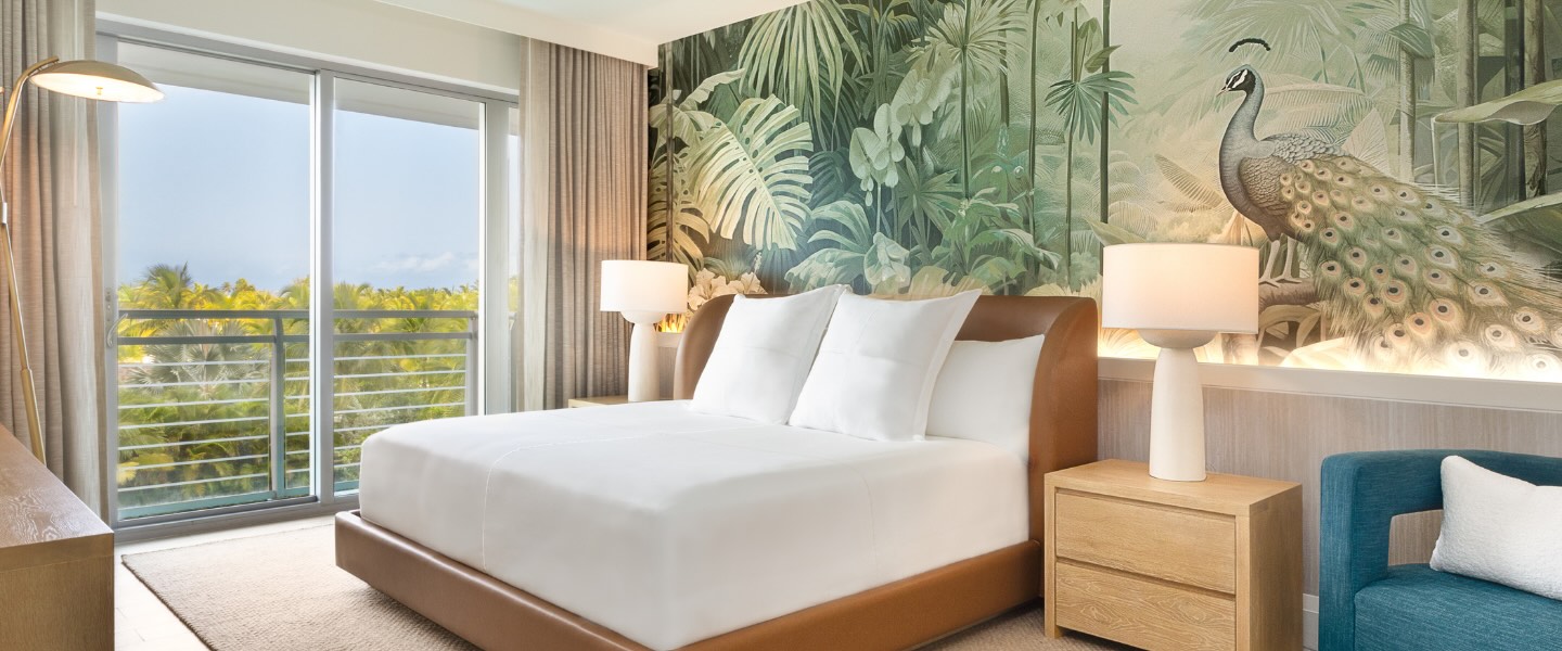 a luxurious room at SLS Baha Mar with a king bed and tropical wallpaper