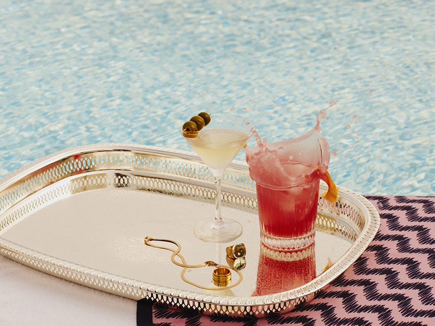 Two cocktails on a silver tray, poolside