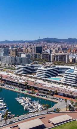 SLS Barcelona, a large resort with three pools, located on a marina with sail boats