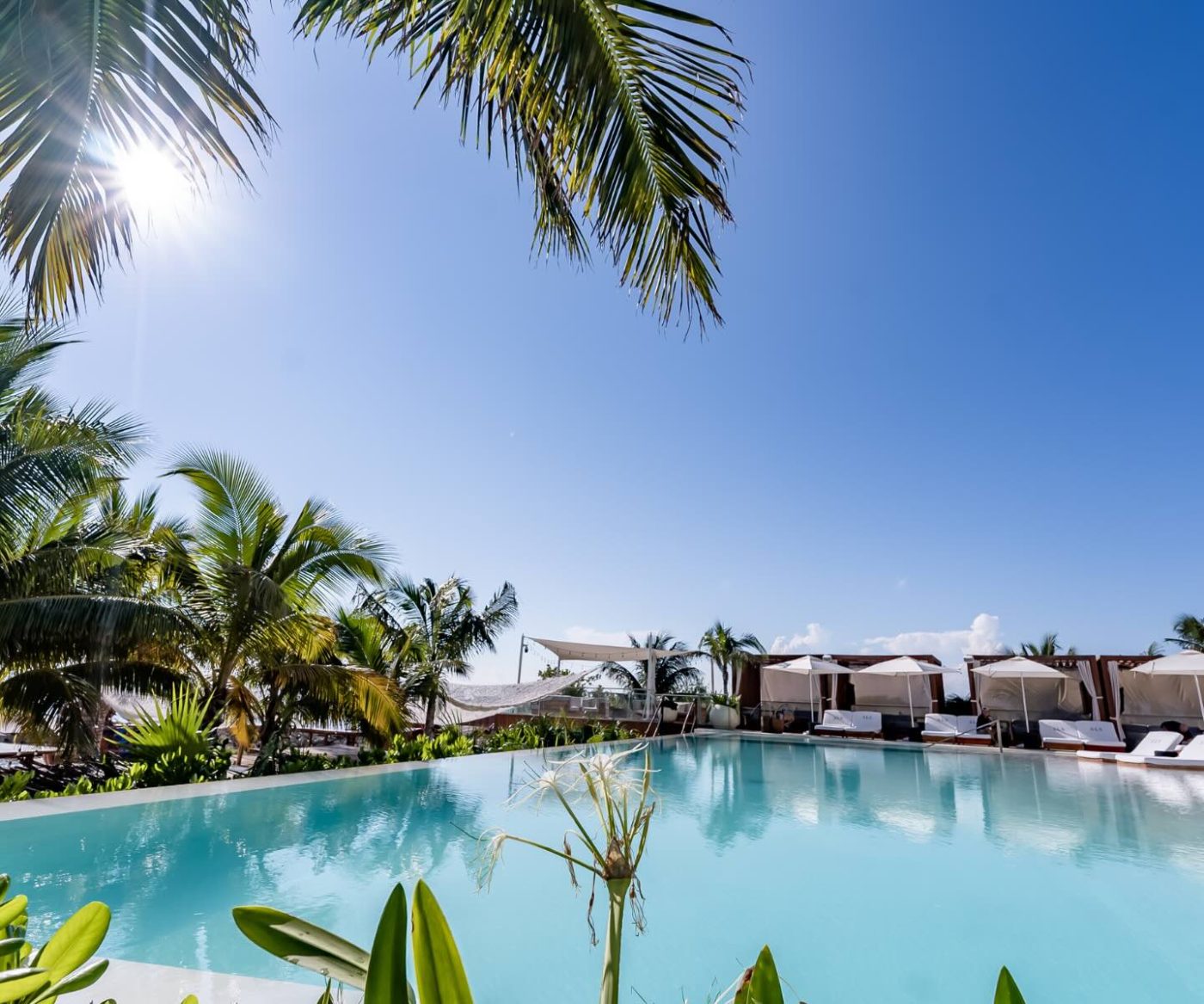 a pool oasis at sls cancun with beach lounges and cabanas